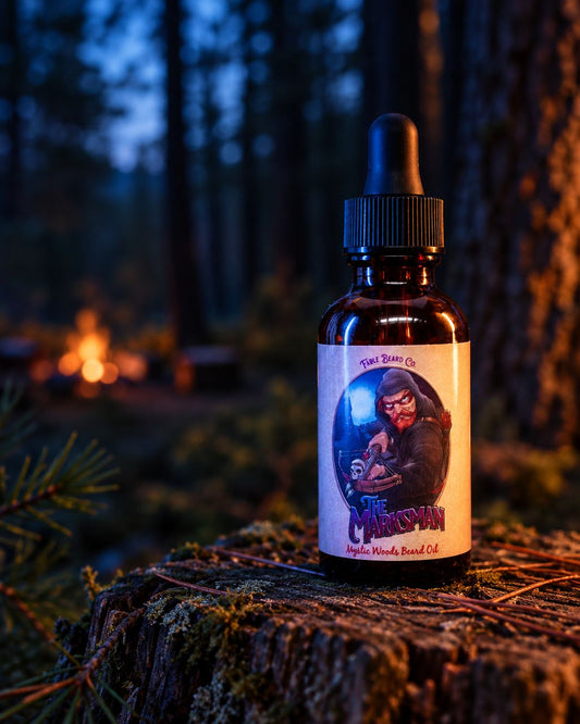 The Marksman beard oil on a woodland stump with a softly blurred campfire behind it.