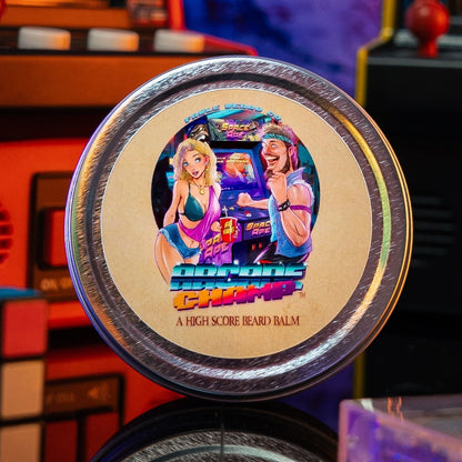 A round tin of Retro Chrome High Score Beard Balm is centered in the foreground, with a colorful retro arcade machine scene blurred in the background.