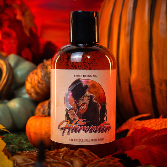 Bottle of 'The Harvester' with a Halloween-themed label against a autumnal background with pumpkins and leaves.